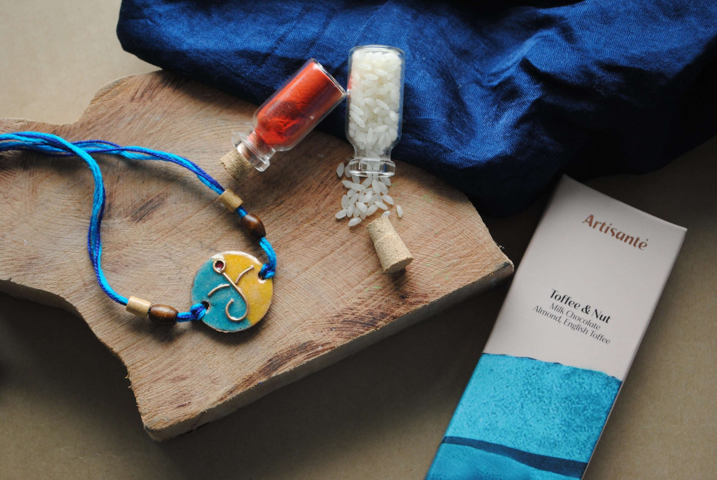 Handcrafted copper enameled rakhi with Ganesh motifs, string threads