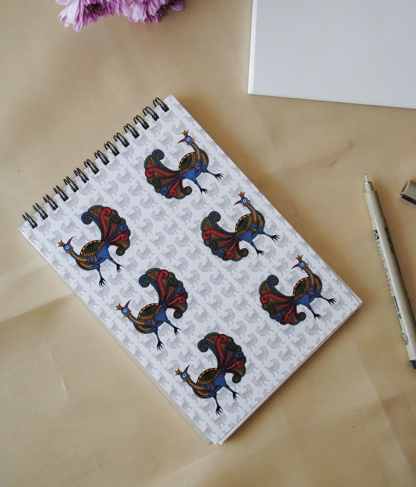 Artwork by native craftsmen of Chitrakathi, Gond, that are used as motifs to create stationery. This one is the peacock motif