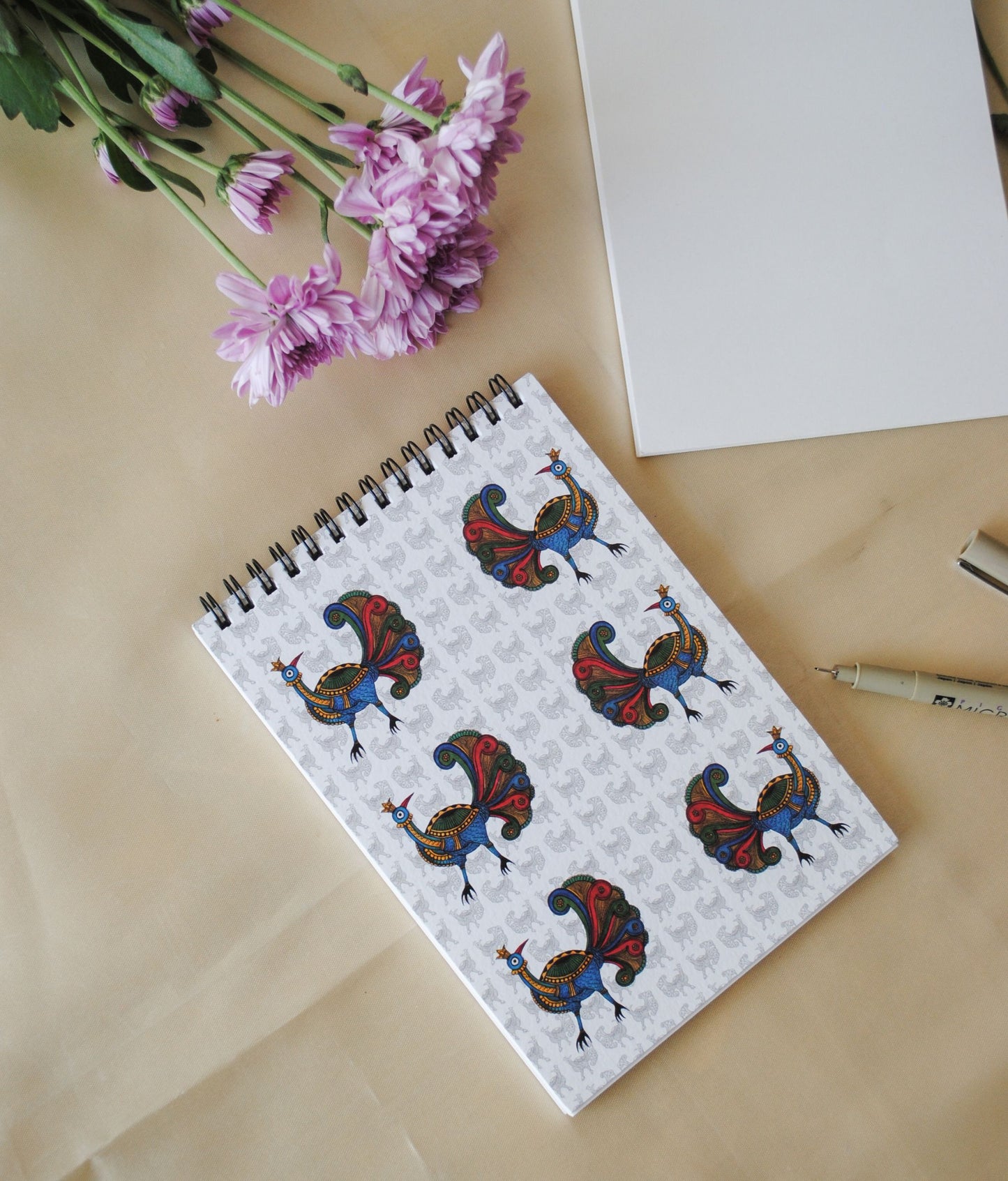 Artwork by native craftsmen of Chitrakathi, Gond, that are used as motifs to create stationery. This one is the peacock motif