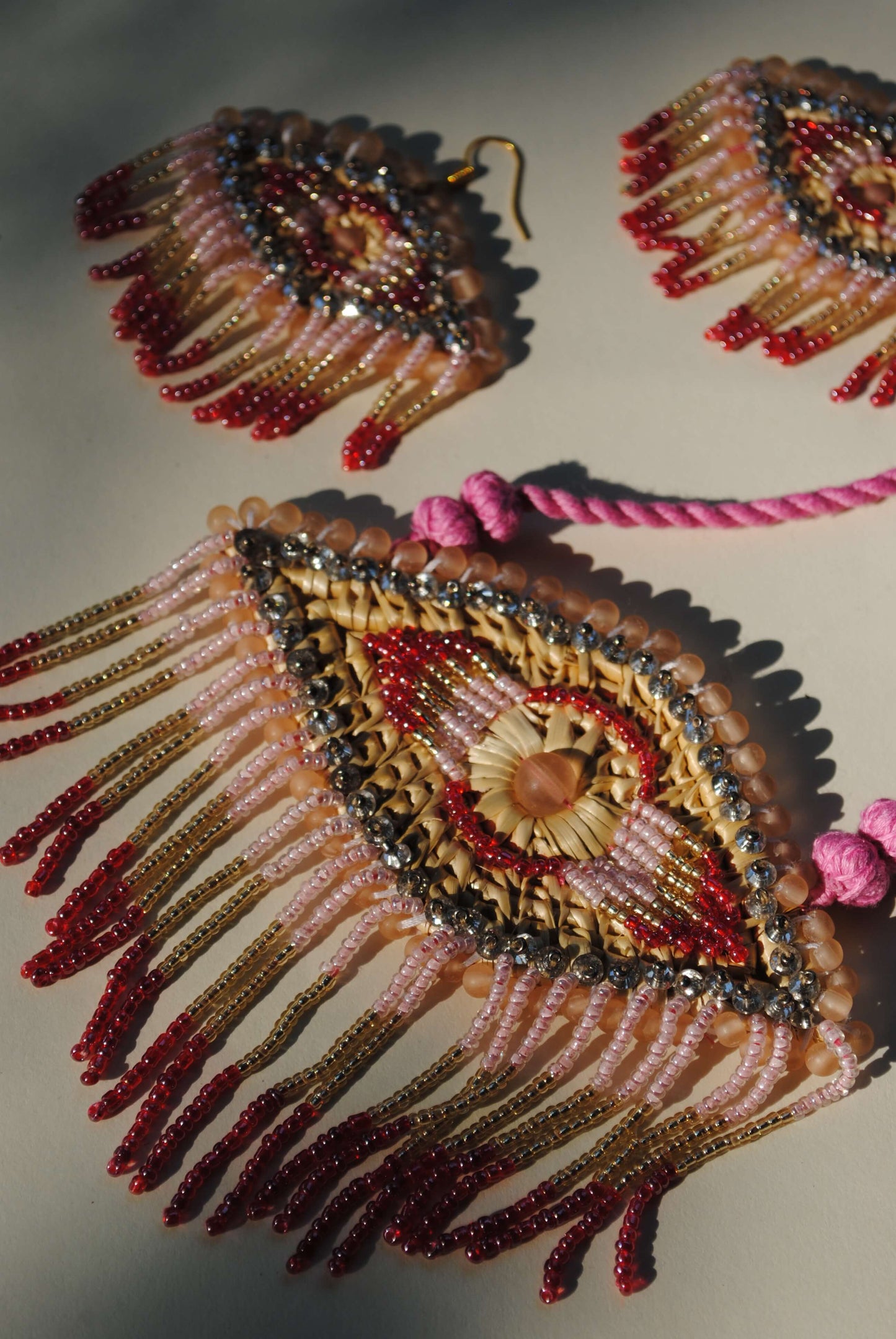 Truna natural fibre golden grass and zardosi handcrafted jewelry from Odisha, nazar pink pendant and earrings set