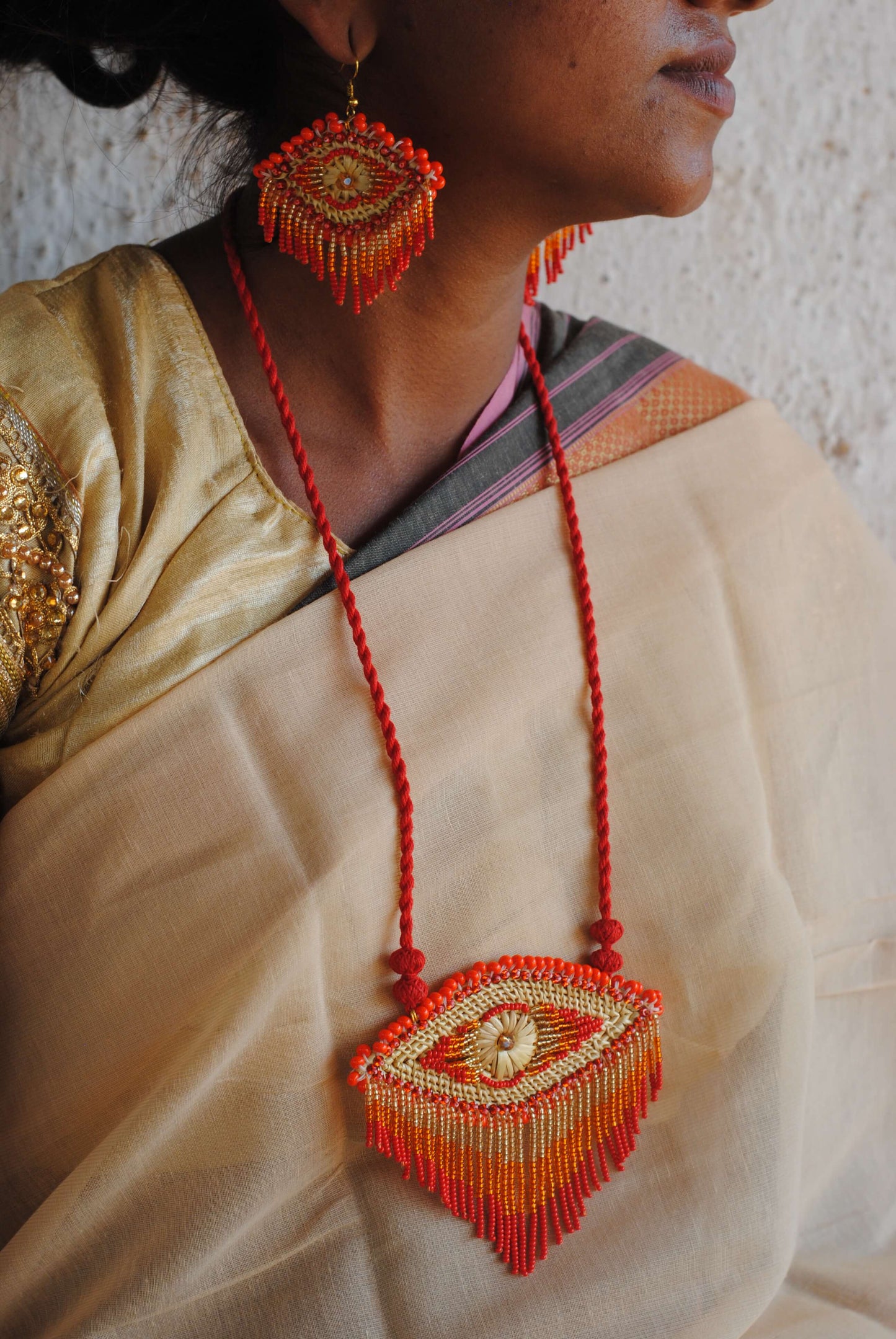 Truna natural fibre golden grass and zardosi handcrafted jewelry from Odisha, nazar red pendant and earrings set