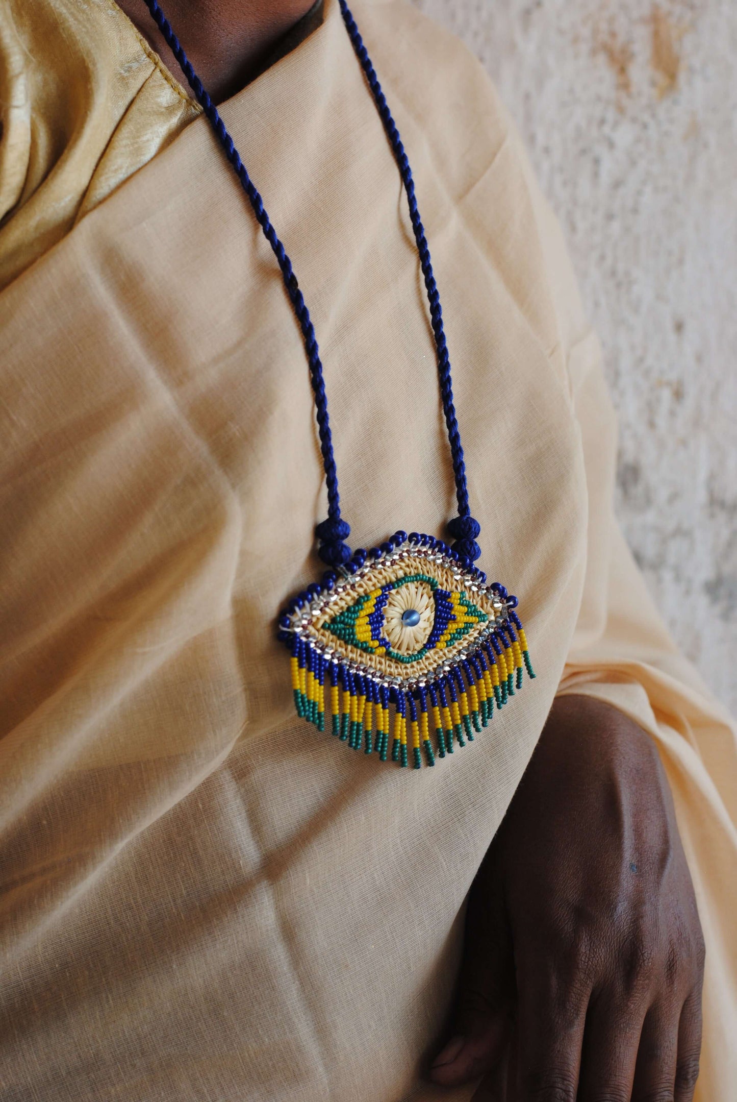 Truna natural fibre golden grass and zardosi handcrafted jewelry from Odisha, nazar blue pendant