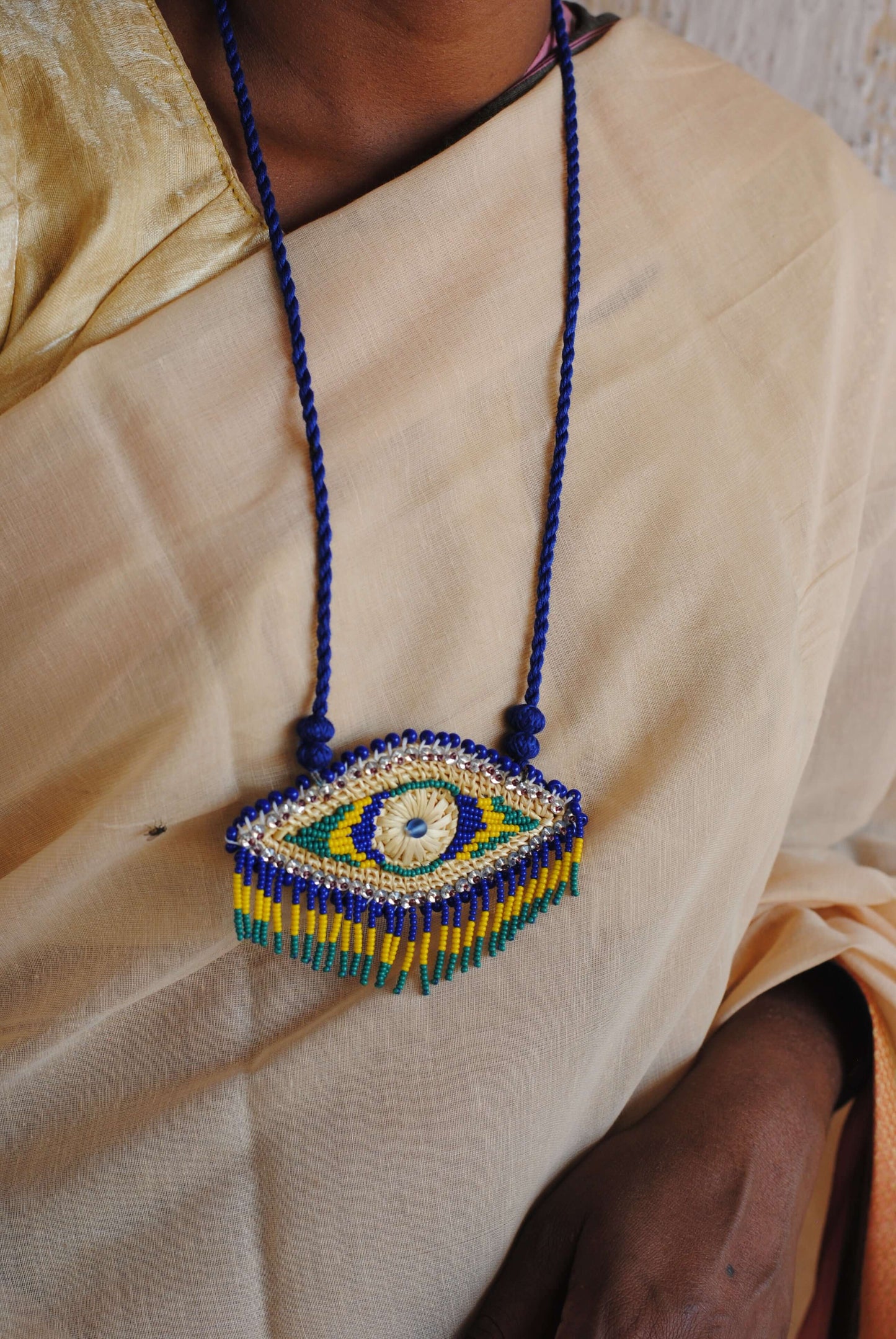 Truna natural fibre golden grass and zardosi handcrafted jewelry from Odisha, nazar blue pendant