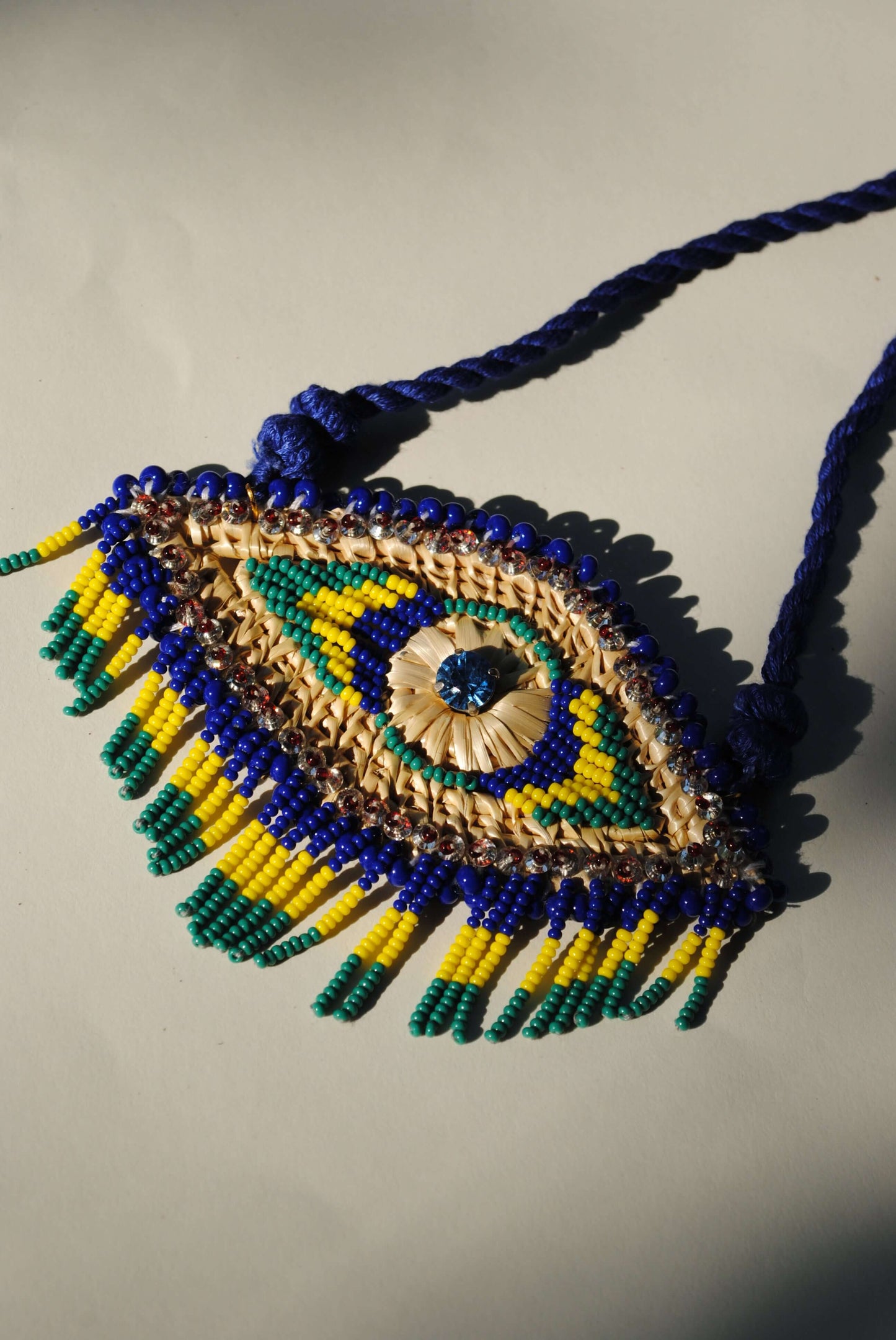 Truna natural fibre golden grass and zardosi handcrafted jewelry from Odisha, nazar blue pendant