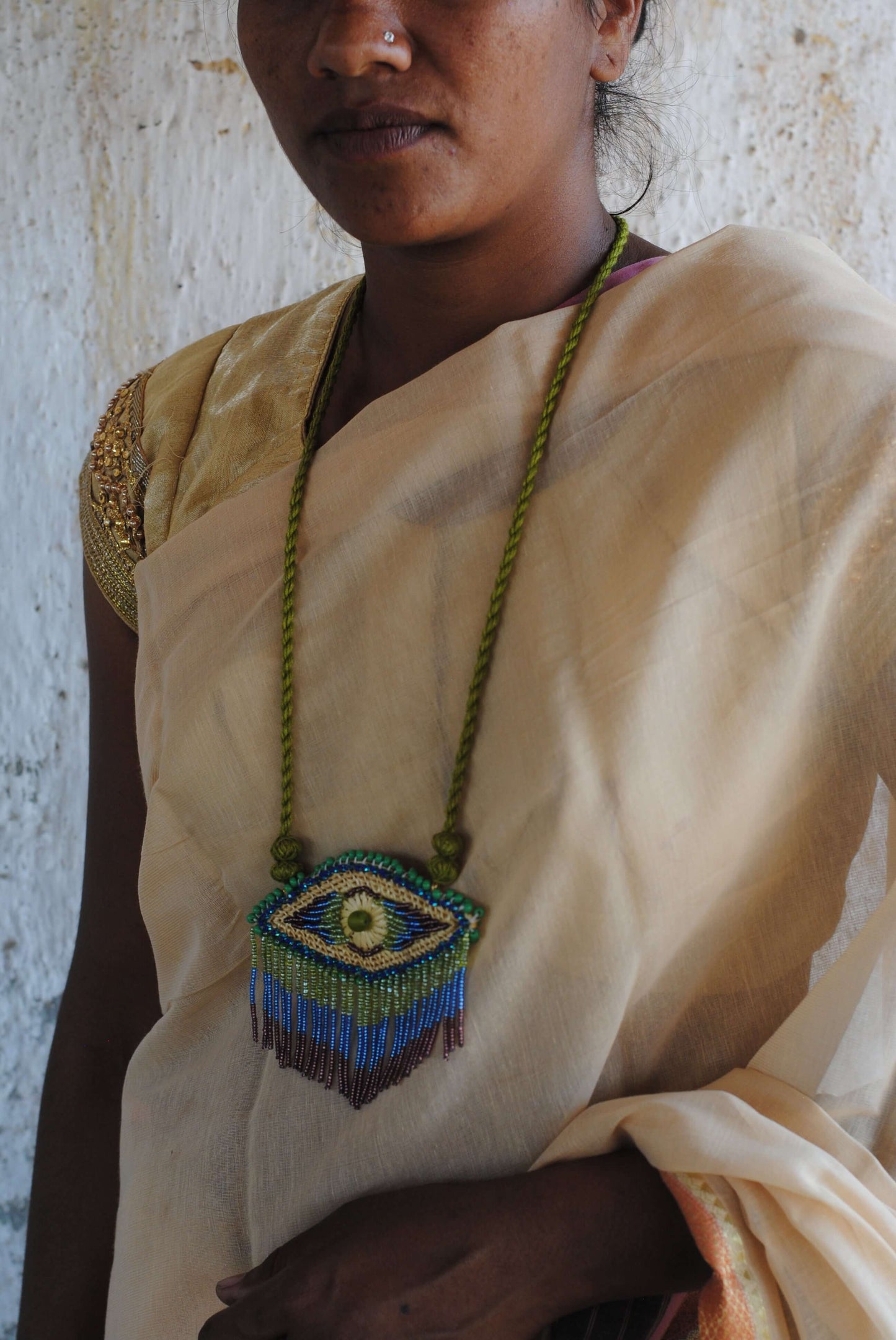 Truna natural fibre golden grass and zardosi handcrafted jewelry from Odisha, nazar blue pendant