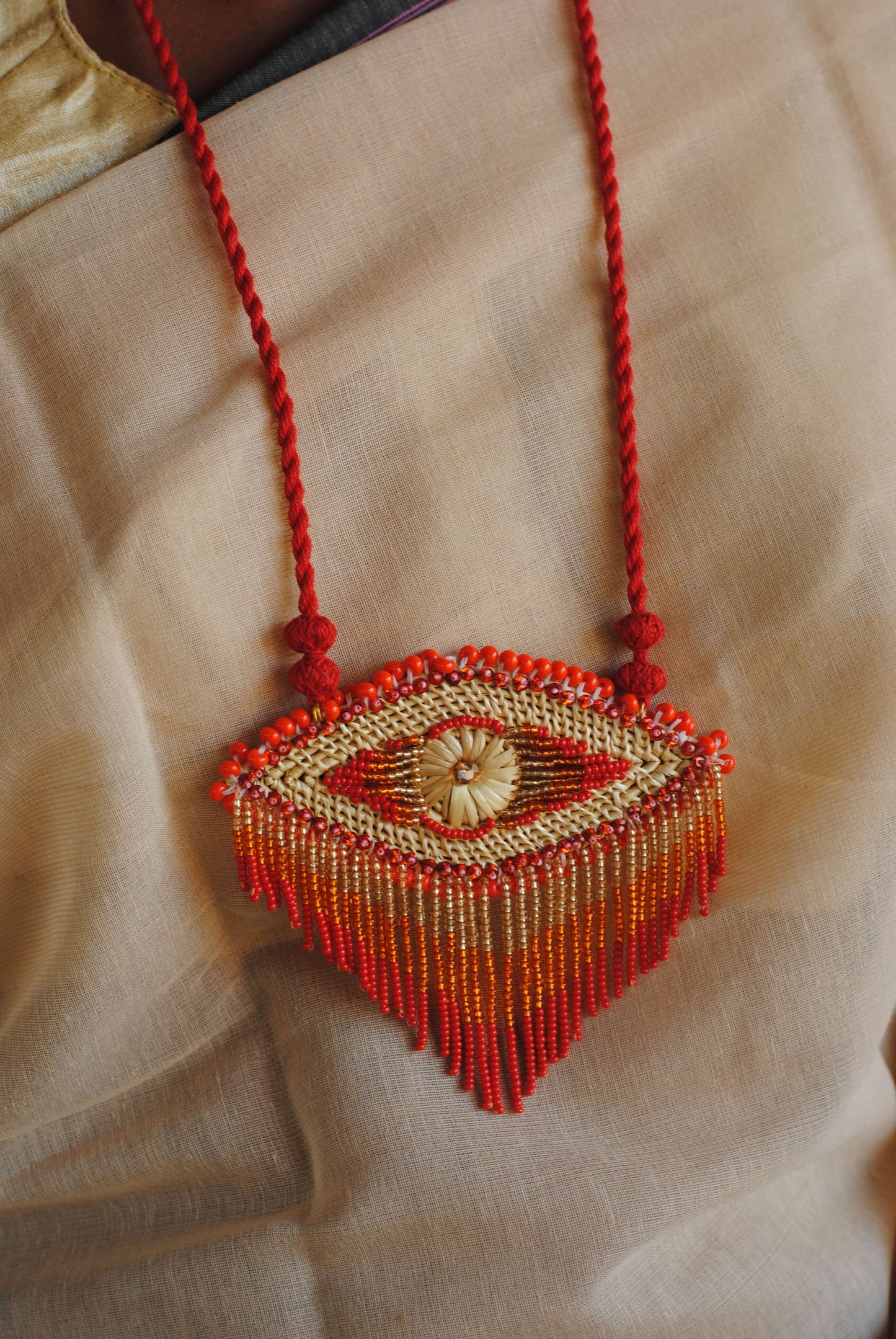 Truna natural fibre golden grass and zardosi handcrafted jewelry from Odisha, nazar red pendant