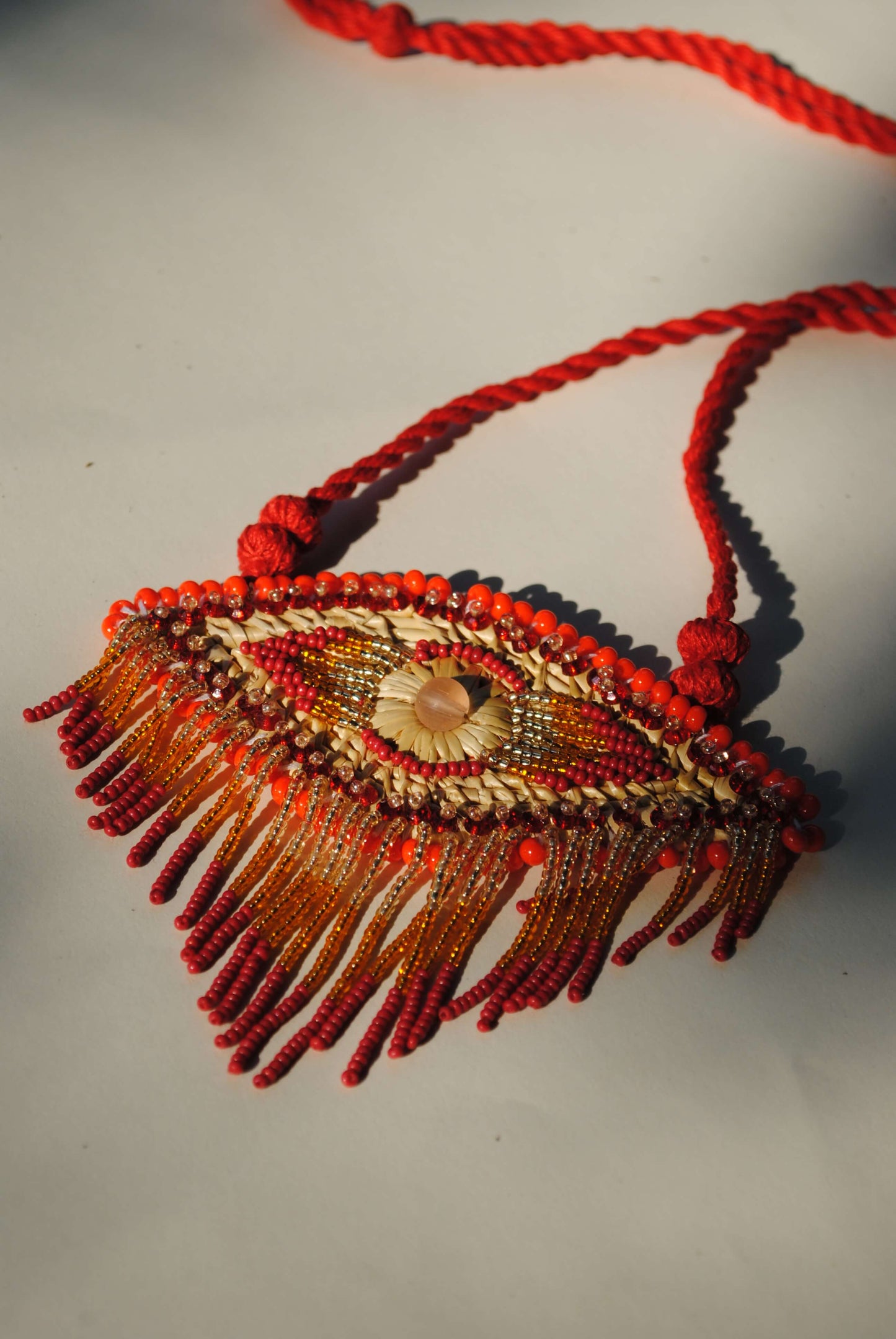 Truna natural fibre golden grass and zardosi handcrafted jewelry from Odisha, nazar red pendant