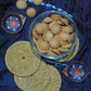 Gift box with copper enamel diya, handwoven coasters and mini cookies