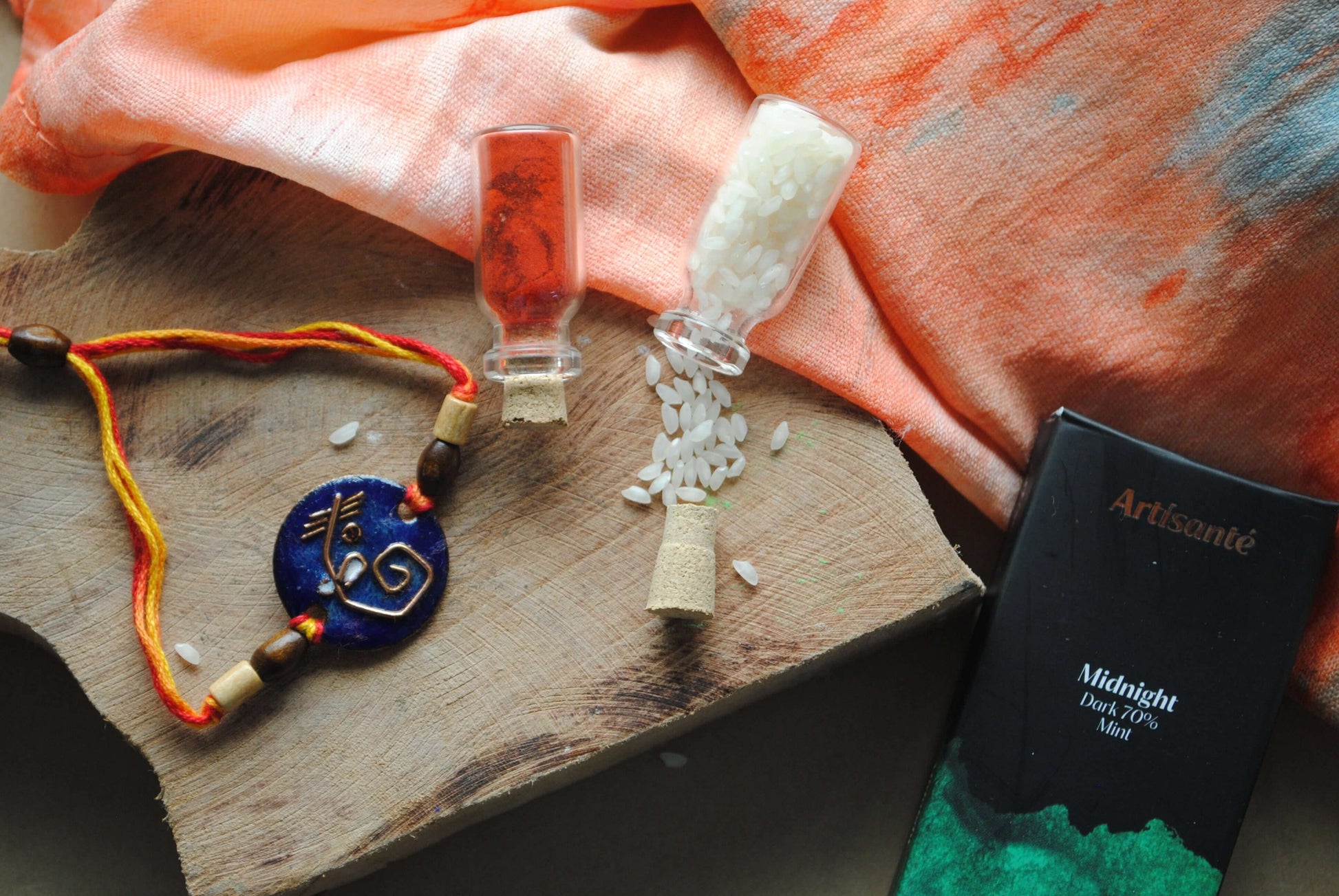 Handcrafted copper enameled rakhi with Ganesh motifs, blue shades and string threads