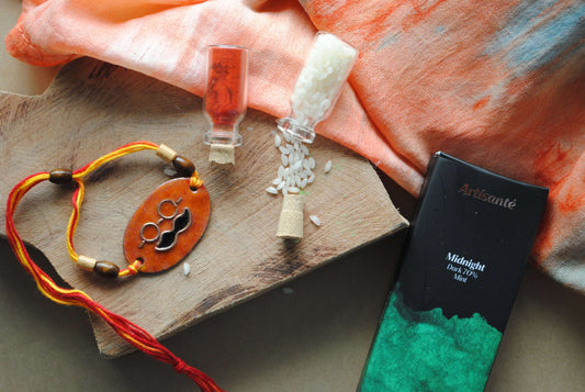 Handcrafted copper enameled rakhi with funky mooch, with a chocolate gift hamper for your sibling