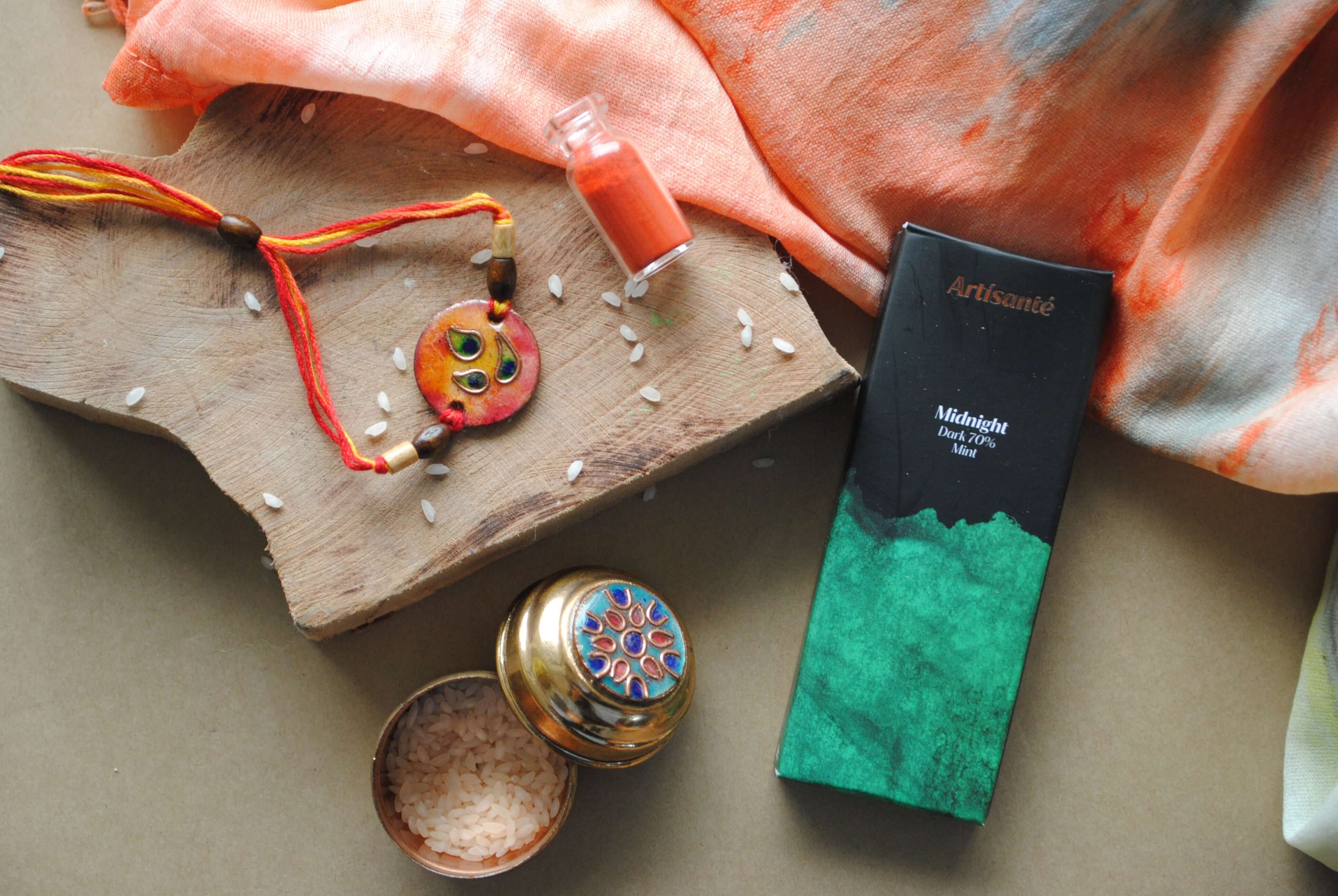 Handcrafted copper enameled rakhi with funky peacock morpankh motif, with a chocolate gift hamper for your sibling