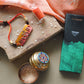 Handcrafted copper enameled rakhi with Om motifs, rectangle, string threads. Part of chocolate gift hamper 