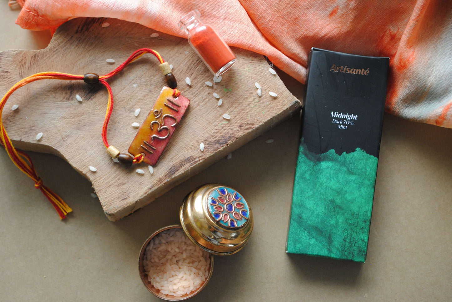 Handcrafted copper enameled rakhi with Om motifs, rectangle, string threads. Part of chocolate gift hamper 