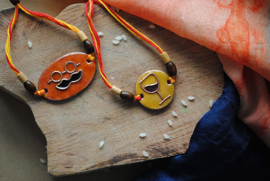 Handcrafted copper enameled rakhi with funky wine motifs, with a chocolate gift hamper for your sibling