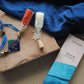 Handcrafted copper enameled rakhi with "sis" in devnagiri, with a chocolate gift hamper