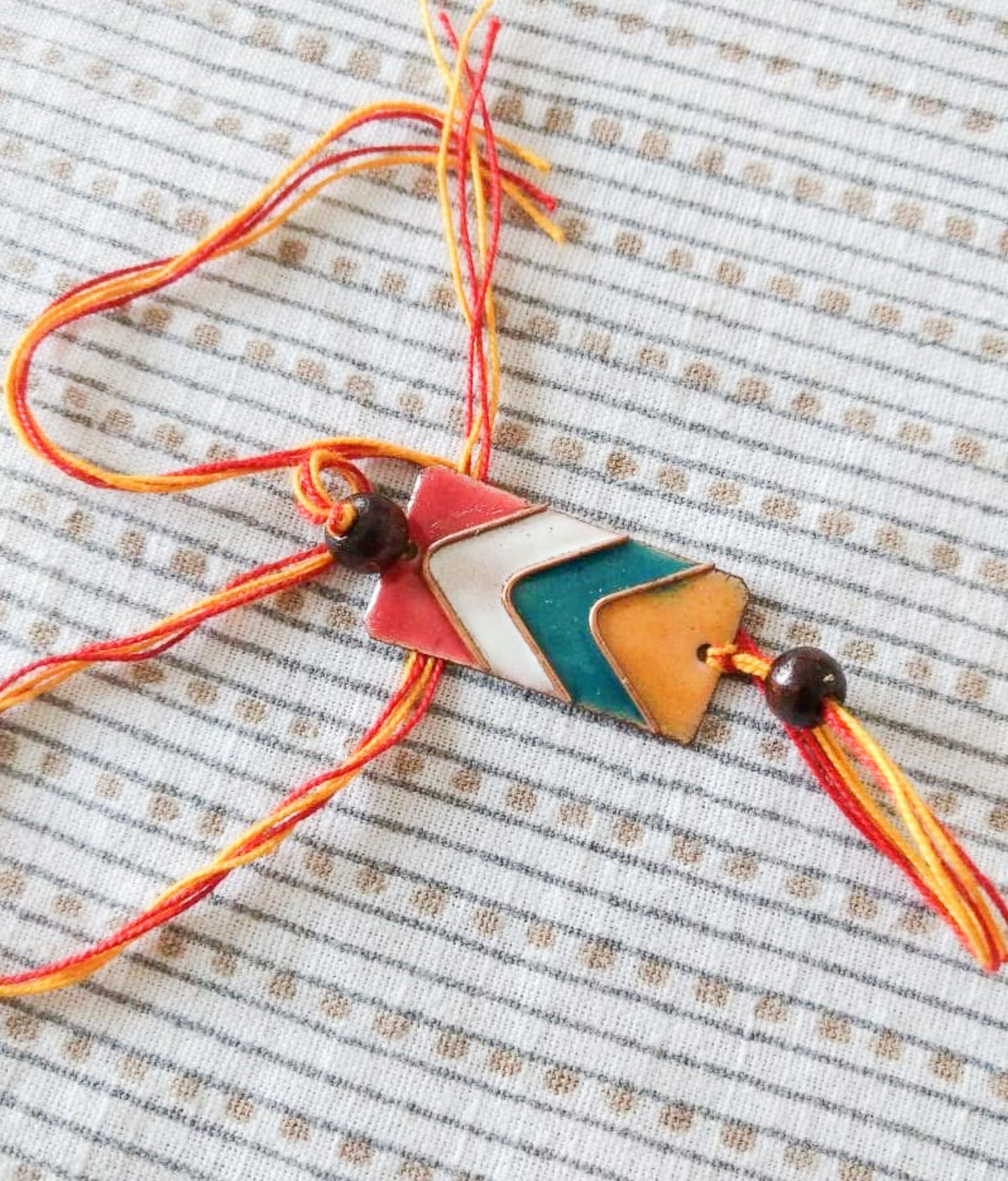 Handcrafted Arrows Copper Enamel Rakhi by Ekibeki (Multicoloured)