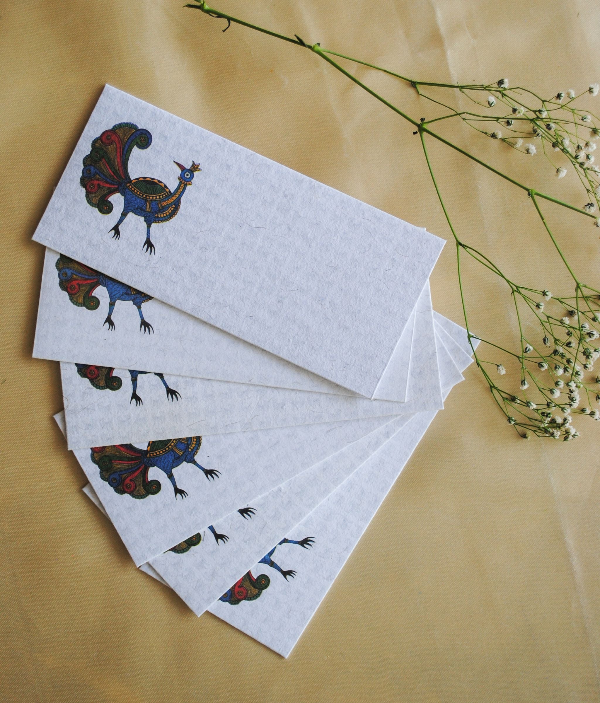 Artwork by native craftsmen of Chitrakathi, Gond, that are used as motifs to create stationery. This one is the peacock motif