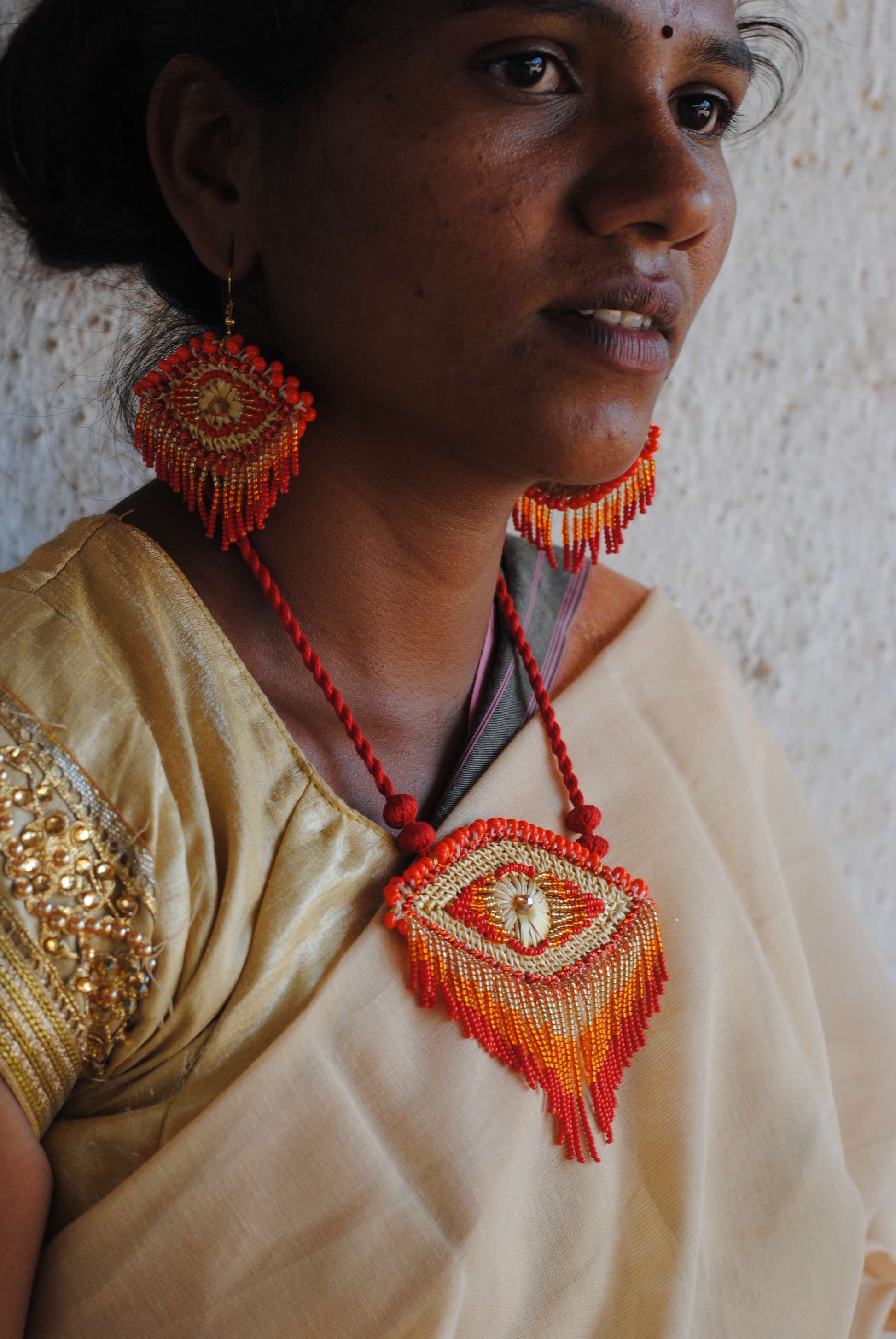 Truna natural fibre golden grass and zardosi handcrafted jewelry from Odisha, nazar red pendant and earrings set
