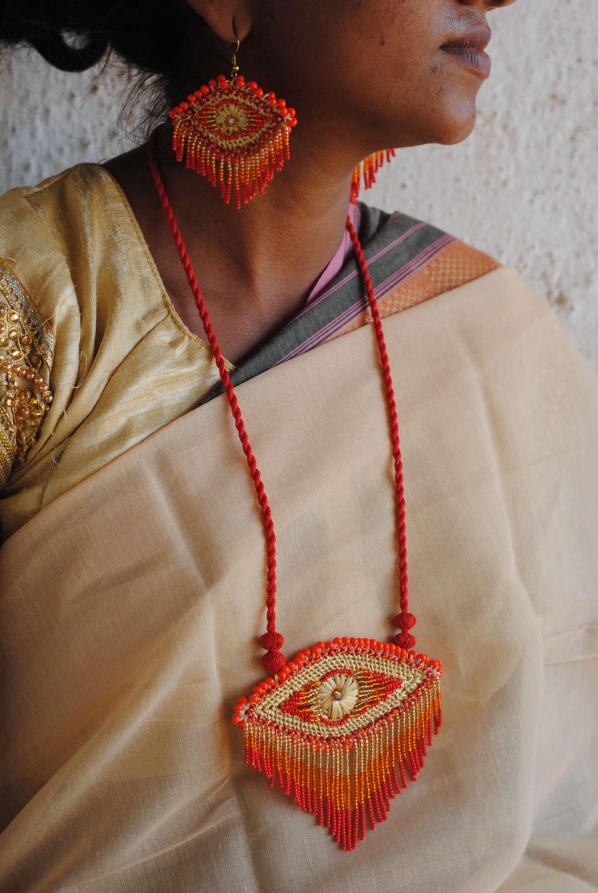 Truna natural fibre golden grass and zardosi handcrafted jewelry from Odisha, nazar red pendant and earrings set